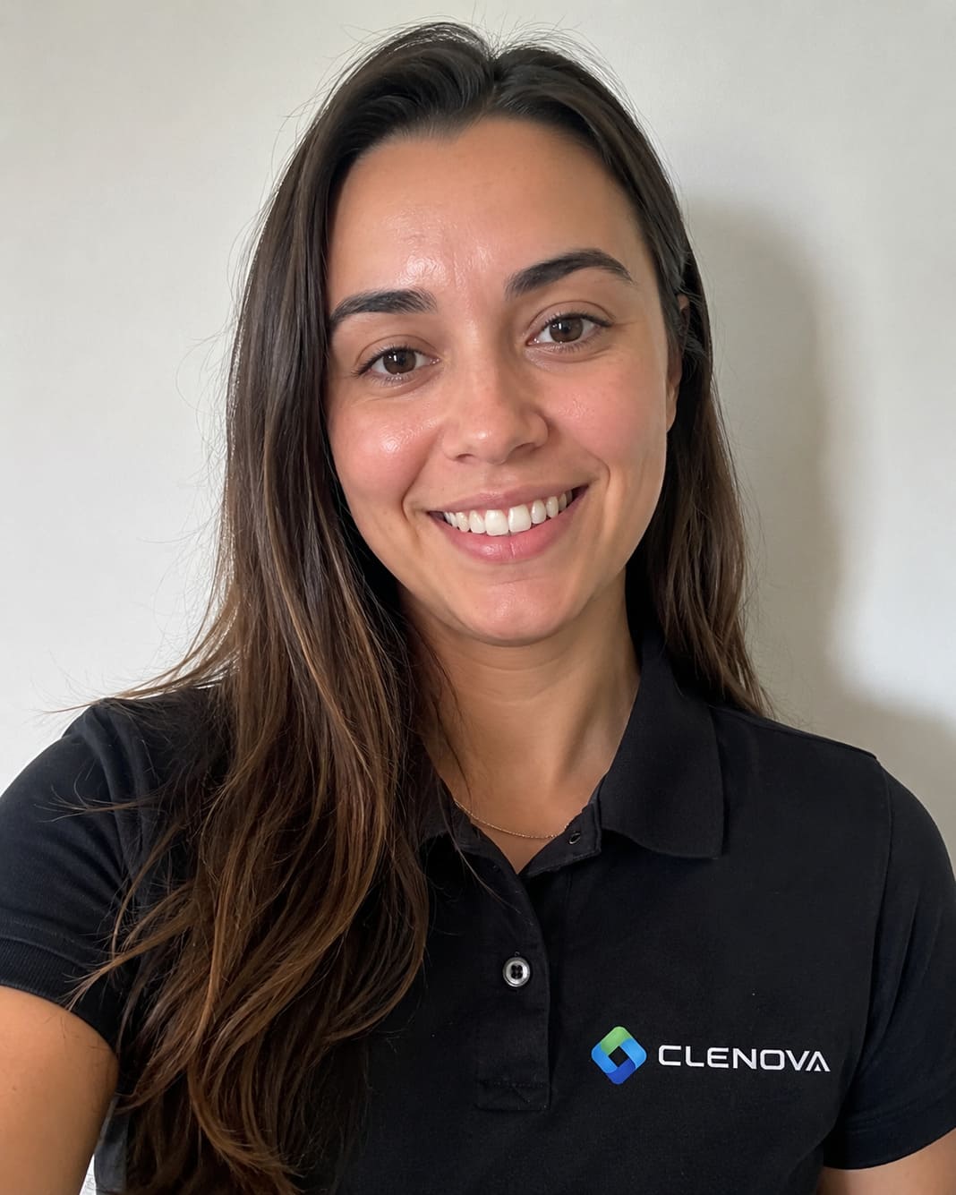 Clenova cleaning staff member smiling in a black polo shirt with logo. – Illustrative Image