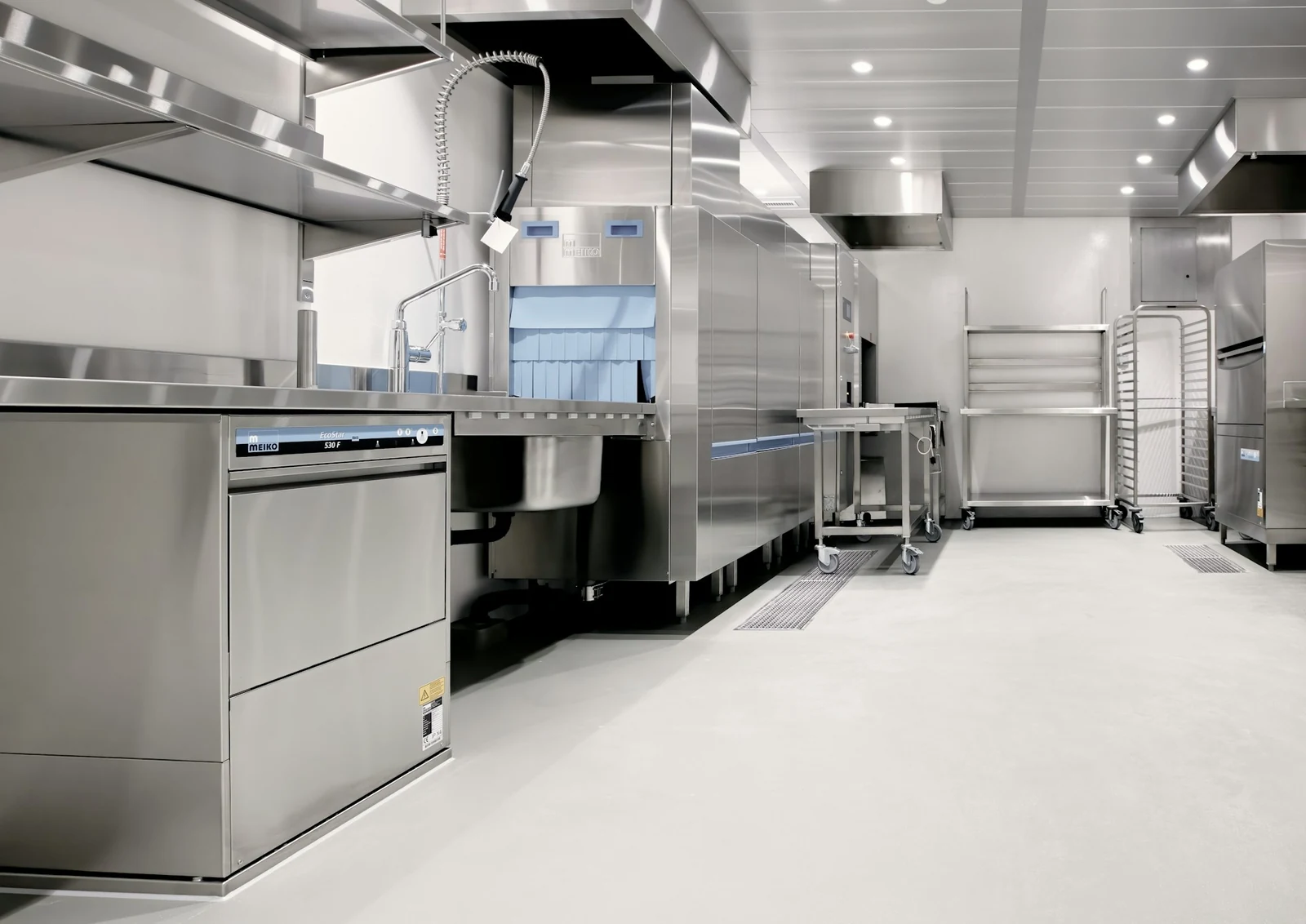 Clean commercial restaurant kitchen with stainless steel equipment, wash stations and hygienic food preparation areas.